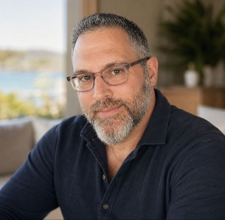 Mark Feinberg, seated by a window, looking at the camera.